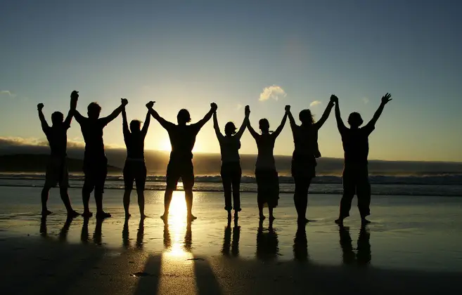 Group Holding Hands on Beach